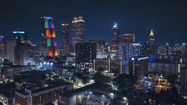 Big city lights ablaze at night: Atlanta, GA Downtown district comes alive. Office skyscrapers illuminate the streets. Drone view