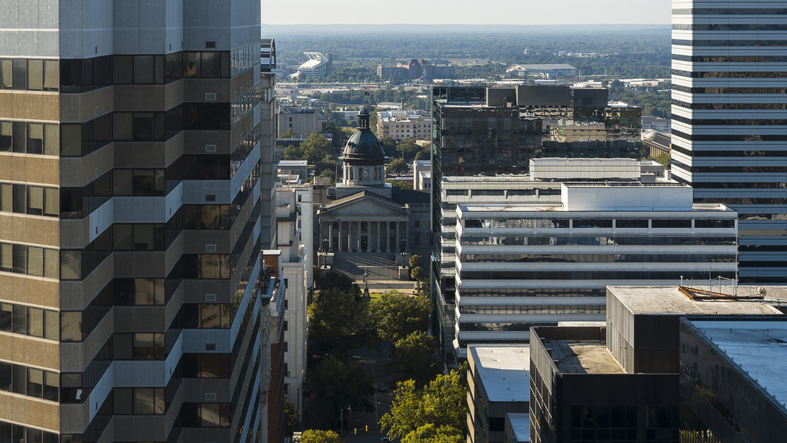 High rise buildings dominate the urban landscape of Columbia, SC. South Carolina State House located in the center of main Street in morning light. Aerial view