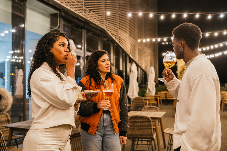 Friends enjoying drinks and food at night party