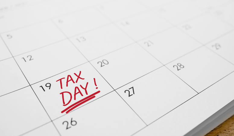 A calendar with the words Tax Day written in red on a specific date. Concept of tax deadline, income tax payment.