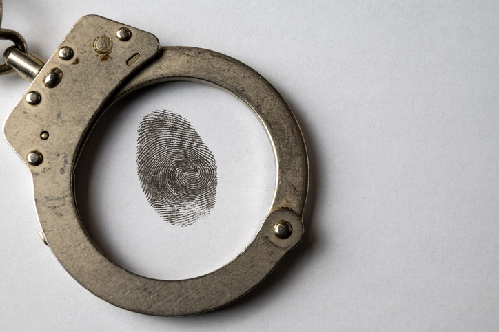 Fingerprint inside handcuffs symbolizing crime and justice
