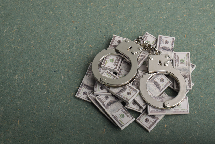 Handcuffs placed on stacks of dollar bills